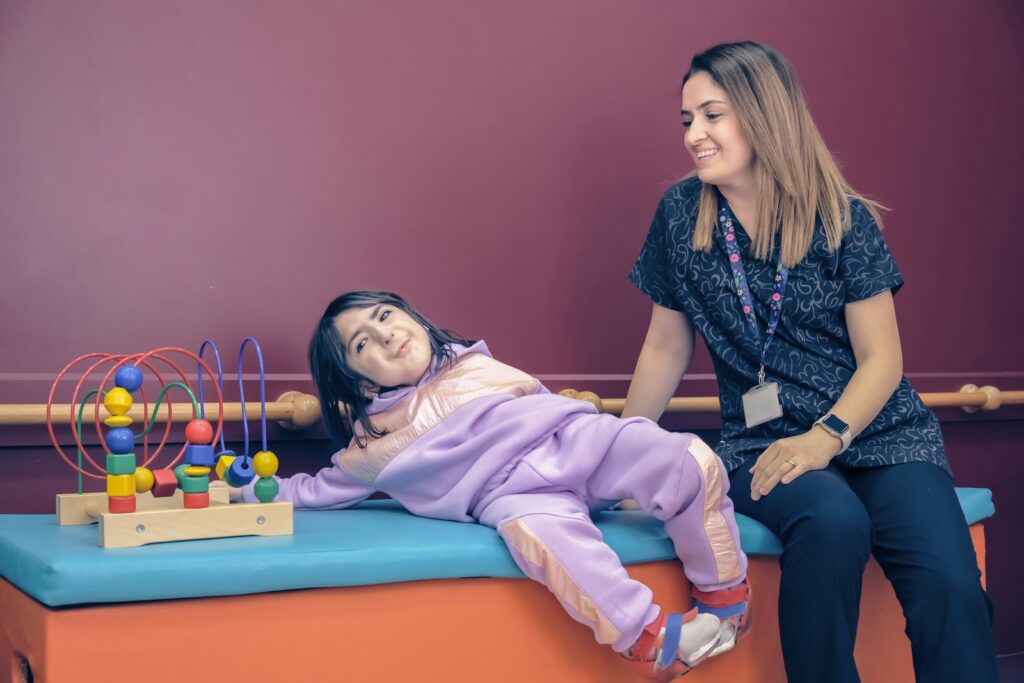 A therapist and a smiling girl in a therapy room