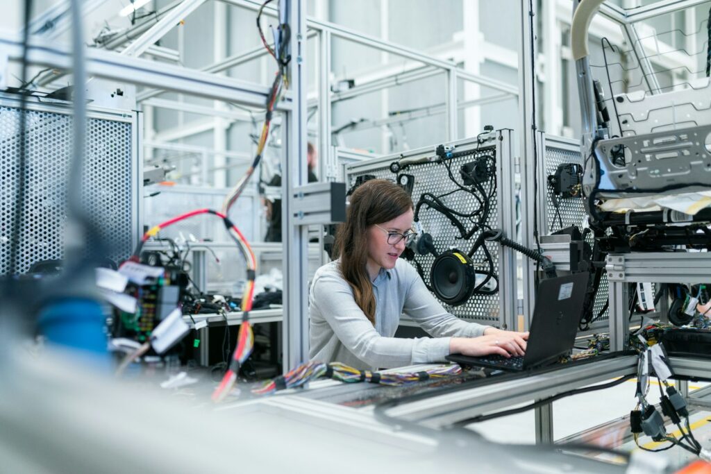 An engineer working at a laptop beside technical equipment